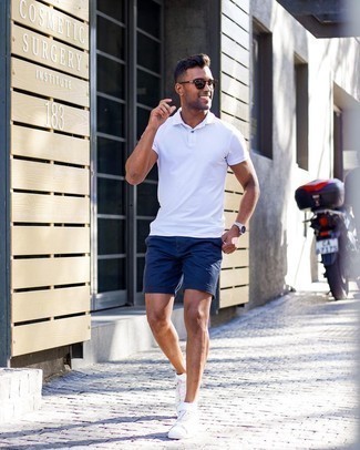 Navy Shorts Outfits For Men: Showcase your skills in menswear styling in this off-duty combo of a white polo and navy shorts. Complete this outfit with white leather low top sneakers and the whole ensemble will come together.