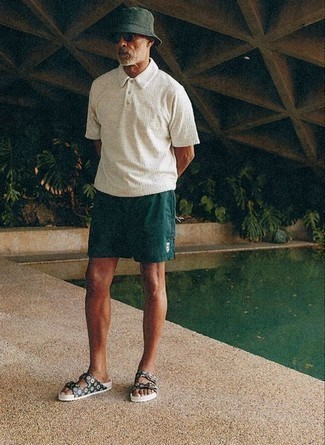 White Polo Outfits For Men: Who said you can't make a fashionable statement with a contemporary outfit? That's easy in a white polo and dark green sports shorts. If you want to effortlessly play down this outfit with a pair of shoes, why not introduce a pair of black print rubber sandals to the equation?