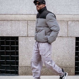 Grey Puffer Jacket Outfits For Men: This combo of a grey puffer jacket and beige cargo pants is uber stylish and provides a cool and casual look. Want to dial it down in the footwear department? Complete your ensemble with white and black leather low top sneakers for the day.