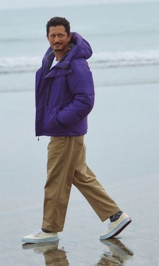 Violet Puffer Jacket Outfits For Men: This combination of a violet puffer jacket and khaki chinos is definitely jaw-dropping, but it's very easy to pull together too. Take an otherwise mostly dressed-up ensemble down a more casual path by rocking beige canvas low top sneakers.