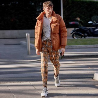 Orange Puffer Jacket Outfits For Men: Bump up your styling game by combining an orange puffer jacket and khaki plaid chinos. Up this whole outfit by finishing off with white athletic shoes.