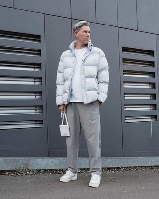 White Leather Low Top Sneakers Outfits For Men: Such essentials as a white puffer jacket and grey chinos are an easy way to infuse some refinement into your casual lineup. Go down a more casual route on the shoe front with a pair of white leather low top sneakers.