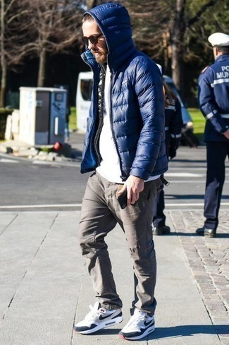 White and Navy Athletic Shoes Outfits For Men: Why not make a blue lightweight puffer jacket and grey ripped jeans your outfit choice? As well as super practical, these pieces look cool when paired together. White and navy athletic shoes add more depth to this outfit.