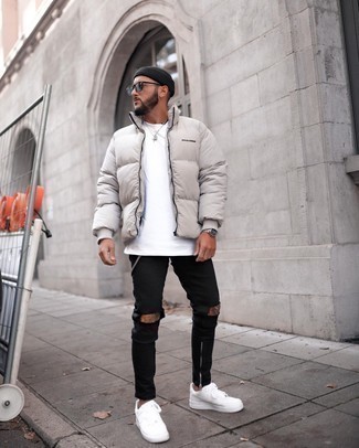 Beige Puffer Jacket Outfits For Men: This combo of a beige puffer jacket and black ripped skinny jeans is proof that a safe casual look doesn't have to be boring. Put an elegant spin on this ensemble by finishing with a pair of white canvas low top sneakers.