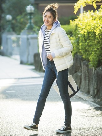 Low Top Sneakers Outfits For Women: A white puffer jacket and navy skinny jeans are absolute staples that will integrate really well within your daily casual routine. Feeling experimental? Tone down your getup by sporting low top sneakers.