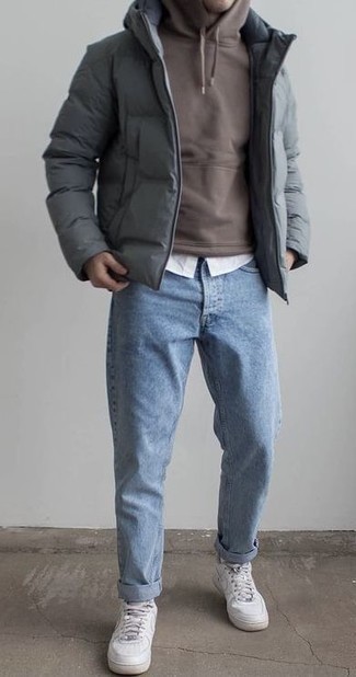 500+ Chill Weather Outfits For Men: This combo of a grey puffer jacket and light blue jeans is a must-try effortlessly sleek ensemble for any gentleman. Unimpressed with this look? Enter white leather low top sneakers to shake things up.
