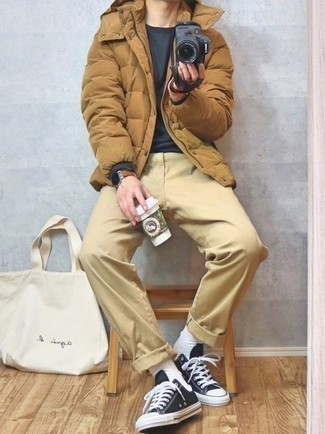 Beige Puffer Jacket Outfits For Men: This pairing of a beige puffer jacket and khaki chinos is a foolproof option when you need to look seriously stylish but have zero time. A pair of black and white canvas low top sneakers immediately kicks up the cool of this ensemble.