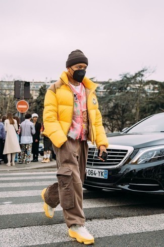 Men's Outfits 2022: A mustard puffer jacket and brown cargo pants? This is easily a wearable outfit that any gentleman can rock on a daily basis. Feeling transgressive today? Shake things up by finishing with a pair of white athletic shoes.