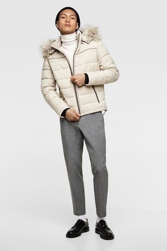 26 Cold Weather Outfits For Men In Their Teens: A beige puffer jacket and grey chinos are the kind of a no-brainer combination that you so terribly need when you have no time to spare. For a smarter vibe, complement your ensemble with black chunky leather derby shoes. This outfit shows that dressing stylishly as you progress through your teenage years is easier than one might think.