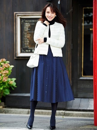 White Puffer Jacket Outfits For Women: Why not go for a white puffer jacket and a navy polka dot midi skirt? As well as super functional, both pieces look stunning when married together. Complete your getup with a pair of black leather pumps to change things up a bit.