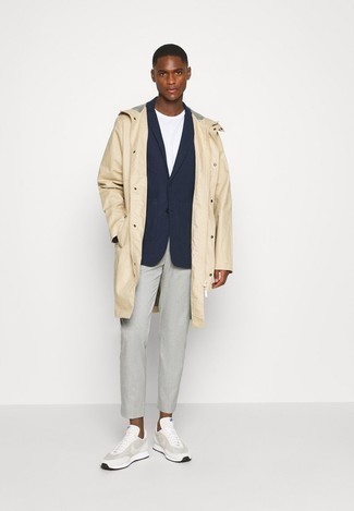 Beige Raincoat Outfits For Men: Effortlessly blurring the line between dapper and off-duty, this combination of a beige raincoat and grey chinos will easily become one of your go-tos. If you don't want to go all out formal, enter grey athletic shoes into the equation.