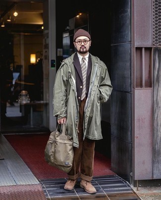 Brown Canvas Tote Bag Outfits For Men: If you feel more confident wearing something comfortable, you'll appreciate this street style pairing of an olive raincoat and a brown canvas tote bag. A pair of tan suede desert boots easily lifts up any getup.