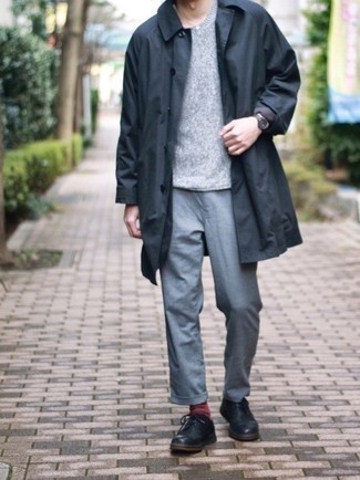 Black Raincoat Outfits For Men: Who said you can't make a stylish statement with an off-duty ensemble? You can do that easily in a black raincoat and grey chinos. You can get a bit experimental in the footwear department and complete your getup with a pair of black leather derby shoes.