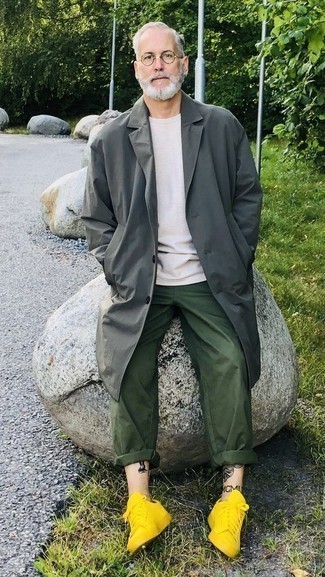 Grey Raincoat Outfits For Men: The formula for a cool laid-back look for men? A grey raincoat with dark green chinos. Add a pair of mustard canvas low top sneakers to the mix to pull the whole thing together.