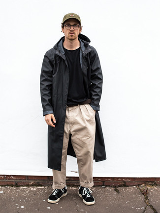 Black Raincoat Outfits For Men: This pairing of a black raincoat and beige chinos is proof that a safe casual outfit doesn't have to be boring. A pair of black and white canvas low top sneakers looks perfect here.