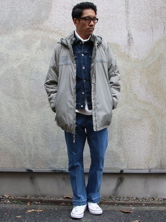 Grey Raincoat Outfits For Men: A grey raincoat and blue jeans matched together are a sartorial dream for those who love casual and cool getups. With footwear, go for something on the casual end of the spectrum and round off your ensemble with a pair of white canvas high top sneakers.