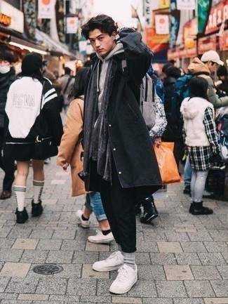 Grey Canvas Backpack Outfits For Men: For comfort dressing with a twist, you can opt for a black raincoat and a grey canvas backpack. Feel somewhat uninspired with this look? Enter white canvas low top sneakers to change things up a bit.