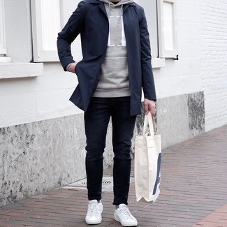 Navy Raincoat Outfits For Men: The combination of a navy raincoat and navy jeans makes for a kick-ass laid-back getup. Look at how great this look is rounded off with white canvas low top sneakers.