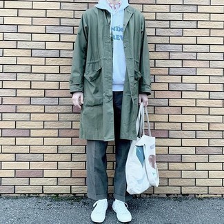 White Canvas Tote Bag Outfits For Men: If you're on the lookout for a casual street style and at the same time stylish outfit, go for a dark green raincoat and a white canvas tote bag. Complete your ensemble with white canvas low top sneakers to instantly switch up the look.