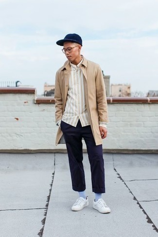 Tan Raincoat Outfits For Men: A tan raincoat and navy chinos are both versatile menswear essentials that will integrate really well within your casual routine. Let your styling expertise really shine by completing this look with a pair of white canvas low top sneakers.