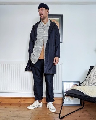 White and Red Canvas Low Top Sneakers Outfits For Men: Solid proof that a navy raincoat and navy chinos look amazing when worn together in a casual look. Now all you need is a nice pair of white and red canvas low top sneakers.