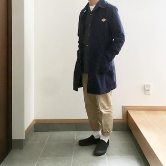 Navy Raincoat Outfits For Men: This off-duty combo of a navy raincoat and khaki chinos is super easy to pull together in no time, helping you look stylish and prepared for anything without spending a ton of time digging through your wardrobe. Black canvas slip-on sneakers will pull your whole outfit together.