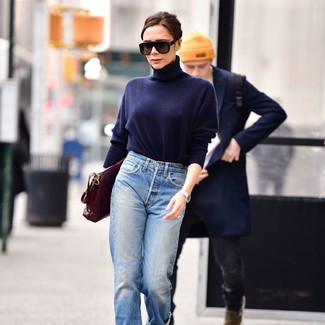 Victoria Beckham wearing Black Sunglasses, Burgundy Leather Satchel Bag, Light Blue Boyfriend Jeans, Navy Turtleneck
