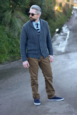 Charcoal Shawl Cardigan Outfits For Men: This pairing of a charcoal shawl cardigan and brown chinos is a must-try casually neat ensemble for any gentleman. To inject a laid-back feel into your outfit, complement this look with navy canvas low top sneakers.
