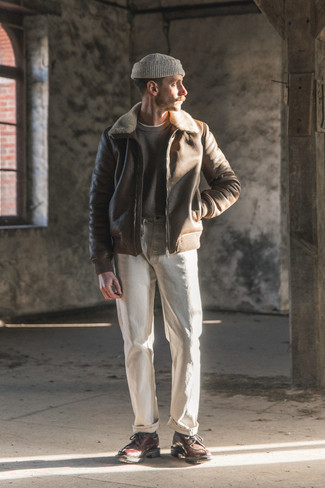 Tobacco Shearling Jacket Outfits For Men: If you feel more confident in functional clothes, you'll appreciate this stylish pairing of a tobacco shearling jacket and white jeans. For something more on the elegant side to complement your outfit, add a pair of dark brown chunky leather derby shoes to this ensemble.