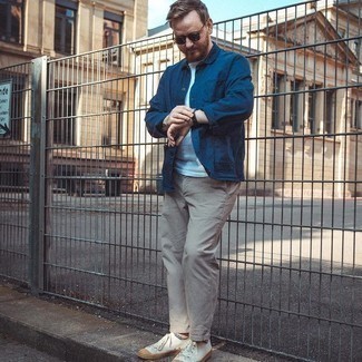 White Canvas Low Top Sneakers Outfits For Men: Opt for a navy shirt jacket and beige chinos to create an interesting and modern-looking ensemble. If you want to effortlessly play down this look with one piece, complete this ensemble with a pair of white canvas low top sneakers.