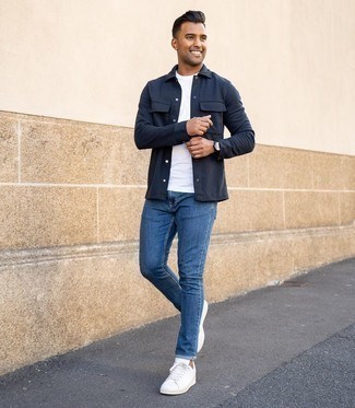 Navy Shirt Jacket Warm Weather Outfits For Men: This laid-back pairing of a navy shirt jacket and blue jeans can only be described as ridiculously dapper. Send an otherwise mostly dressed-up ensemble a more casual path by rounding off with white leather low top sneakers.