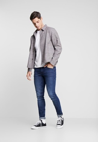 Navy Skinny Jeans Outfits For Men: Such pieces as a grey plaid shirt jacket and navy skinny jeans are the ideal way to infuse toned down dapperness into your day-to-day repertoire. Black and white canvas low top sneakers are a stylish complement to this ensemble.
