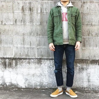 Slip-on Sneakers Outfits For Men: This laid-back combo of an olive shirt jacket and navy jeans is capable of taking on different forms depending on the way you style it out. A pair of slip-on sneakers looks perfectly at home with this outfit.