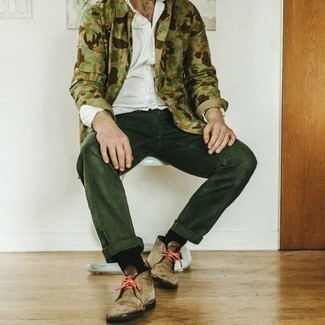 Dark Green Jeans Outfits For Men: Effortlessly blurring the line between cool and casual, this pairing of an olive camouflage shirt jacket and dark green jeans will easily become your go-to. The whole getup comes together if you complete your look with a pair of tan suede desert boots.