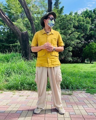Dark Green Bucket Hat Outfits For Men: Try teaming a mustard short sleeve shirt with a dark green bucket hat for comfort dressing with an edgy spin. A pair of beige athletic shoes is a good option to round off this look.