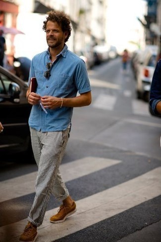 Dark Brown Suede Low Top Sneakers Outfits For Men: Opt for a light blue chambray short sleeve shirt and white and navy vertical striped chinos to feel 100% confident in yourself and look fashionable. Let your styling skills really shine by completing this look with dark brown suede low top sneakers.