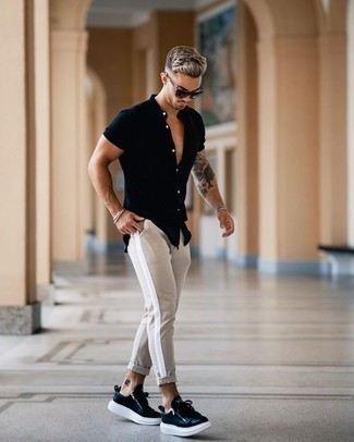 Navy Leather Low Top Sneakers Outfits For Men: You'll be amazed at how easy it is for any man to get dressed like this. Just a navy short sleeve shirt and beige chinos. Look at how nice this ensemble is finished off with navy leather low top sneakers.