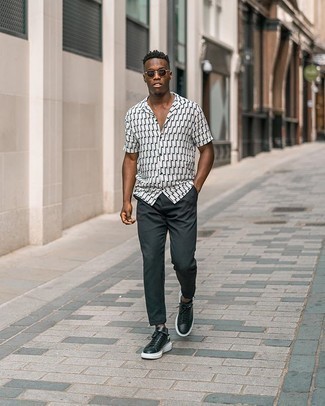 White and Black Print Short Sleeve Shirt Outfits For Men: A white and black print short sleeve shirt and charcoal chinos will give off this relaxed and dapper vibe. Black and white leather low top sneakers tie the getup together.