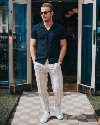 Beige Vertical Striped Chinos Outfits: Consider wearing a navy short sleeve shirt and beige vertical striped chinos to achieve an interesting and current casual ensemble. Let your styling prowess really shine by finishing your outfit with white canvas low top sneakers.