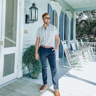Brown Leather Belt Outfits For Men: Try pairing a white and blue vertical striped short sleeve shirt with a brown leather belt for relaxed dressing with an edgy twist. Don't know how to finish this look? Wear a pair of brown leather slip-on sneakers to kick up the fashion factor.