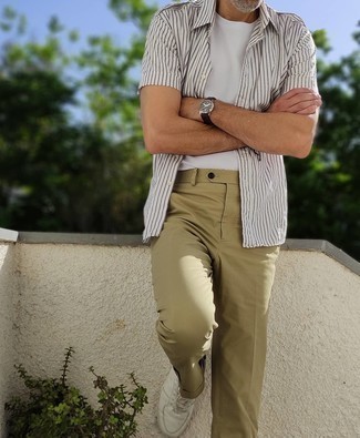 Watch Outfits For Men: Pair a white and black vertical striped short sleeve shirt with a watch for a trendy and easy-going outfit. Infuse an extra touch of style into this outfit with a pair of white leather low top sneakers.
