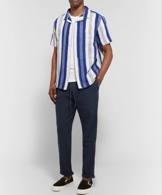 White and Navy Short Sleeve Shirt Outfits For Men: For an off-duty ensemble, team a white and navy short sleeve shirt with navy chinos — these pieces work perfectly together. Introduce black canvas slip-on sneakers to the mix and the whole outfit will come together.