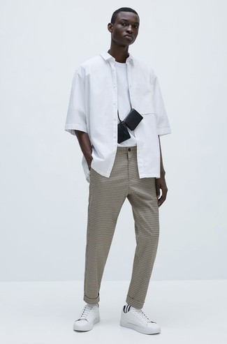 Neck Pouch Outfits For Men: Demonstrate your chops in men's fashion in this edgy combination of a white short sleeve shirt and a neck pouch. White canvas low top sneakers are the most effective way to transform this look.