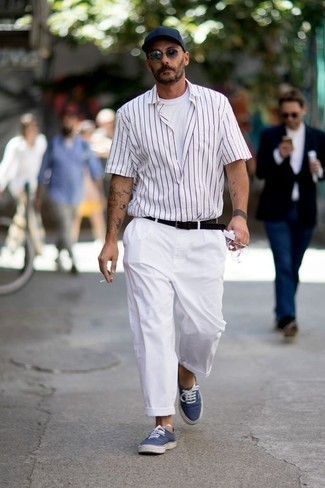 Navy and White Canvas Low Top Sneakers Outfits For Men: Combining a white vertical striped short sleeve shirt with white chinos is an amazing option for a relaxed getup. Complete this outfit with navy and white canvas low top sneakers and ta-da: the ensemble is complete.