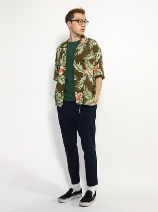Olive Floral Short Sleeve Shirt Outfits For Men: This combination of an olive floral short sleeve shirt and navy chinos will prove your prowess in menswear styling even on dress-down days. Black canvas slip-on sneakers will be the perfect companion to your look.