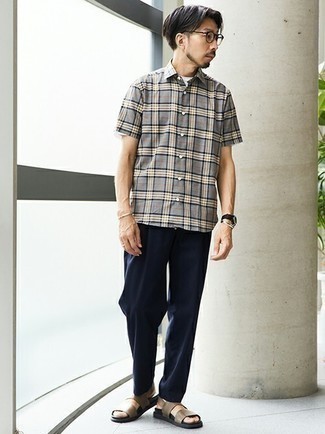 Brown Leather Sandals Outfits For Men: A grey plaid short sleeve shirt and navy chinos are absolute menswear staples that will integrate brilliantly within your daily fashion mix. When this ensemble is too much, dress it down by slipping into a pair of brown leather sandals.