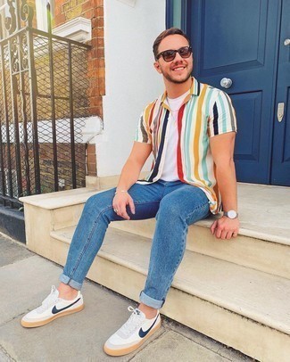 Multi colored Vertical Striped Short Sleeve Shirt Outfits For Men: Try teaming a multi colored vertical striped short sleeve shirt with blue jeans for a practical ensemble that's also put together. This look is complemented perfectly with a pair of white and navy leather low top sneakers.