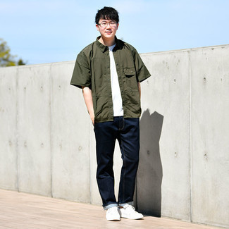 Olive Short Sleeve Shirt Outfits For Men: Go for a simple but casually cool ensemble in an olive short sleeve shirt and navy jeans. A pair of white canvas low top sneakers serves as the glue that ties this ensemble together.