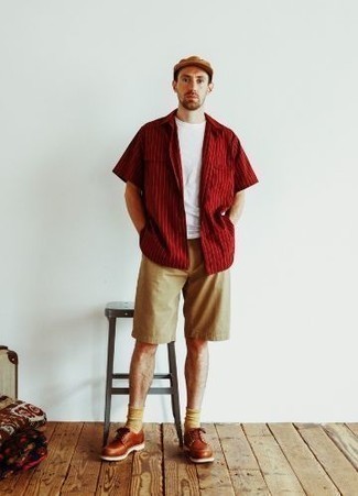 Men's Outfits 2022: This laid-back combination of a red vertical striped short sleeve shirt and tan shorts is perfect if you want to go about your day with confidence in your ensemble. Let your outfit coordination chops really shine by finishing with a pair of tobacco leather derby shoes.