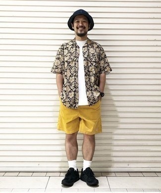 Yellow Shorts Outfits For Men: You'll be surprised at how easy it is for any man to get dressed this way. Just a black floral short sleeve shirt teamed with yellow shorts. Jazz up your look with more casual footwear, such as these black athletic shoes.